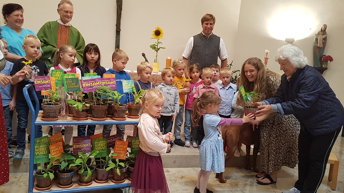 Die Kinder des Kindergartens Kiefersfelden übergaben die Pflanzen im Rahmen eines Gottesdienstes an die Seniorinnen und Senioren. Foto: Landratsamt Rosenheim