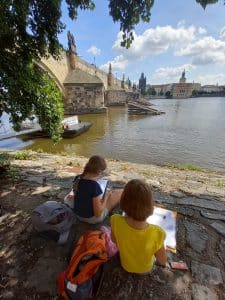 Zwei Kinder zeichnen an der Karlsbrücke in Prag