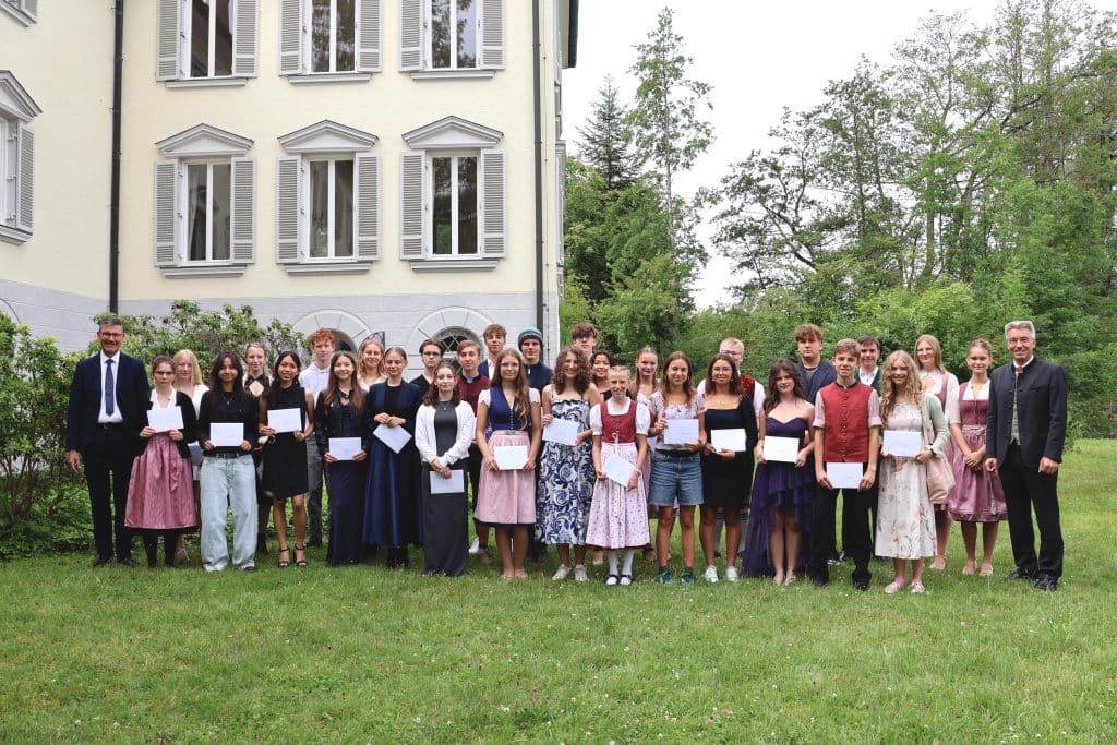 Gruppenbild der Absolventinnen und Absolventen vor dem Schloss.