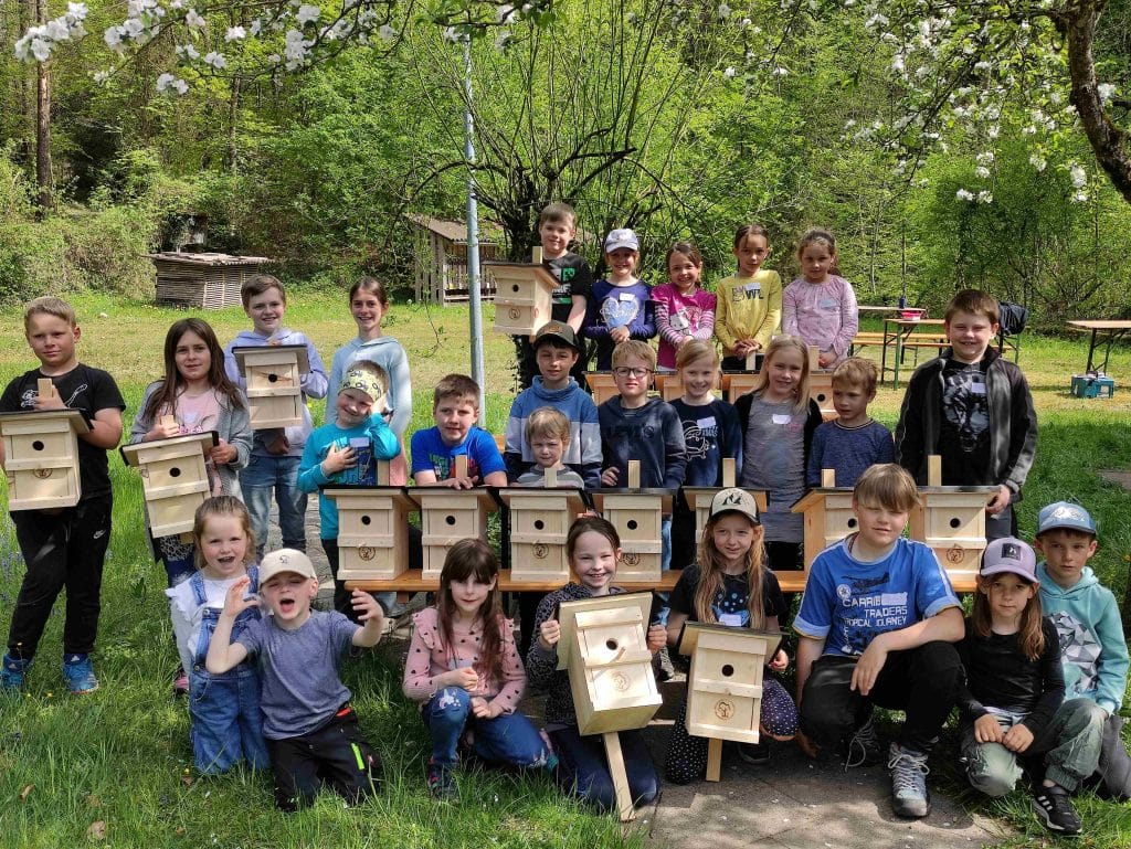 Gruppenbild von Kindern mit ihren selbstgebauten Vogelhäuschen.