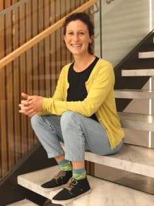 Rahel Wacker sitzt lächelnd auf einer Treppe.
