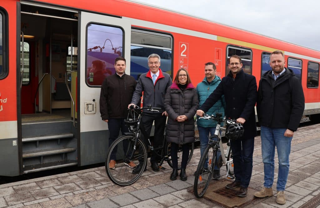 Gruppenbild mit Fahrrädern vor einem Zug.